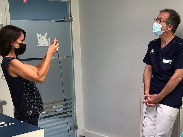 Une personne portant un masque facial se tenant à côté d’une personne portant un masque.