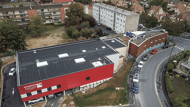 Un bâtiment avec des voitures garées sur le côté.
