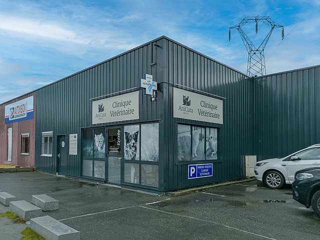 Un immeuble avec une voiture garée à l’extérieur.