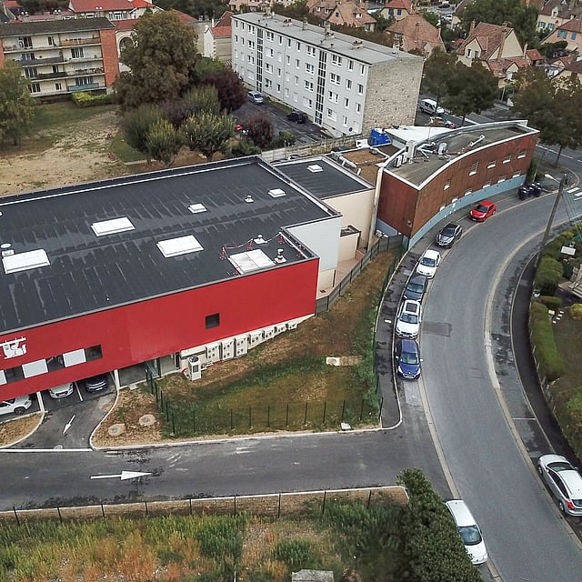Un bâtiment avec des voitures garées sur le côté.