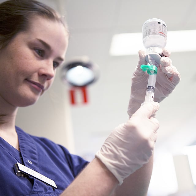 Une infirmière tenant une perfusion intraveineuse.