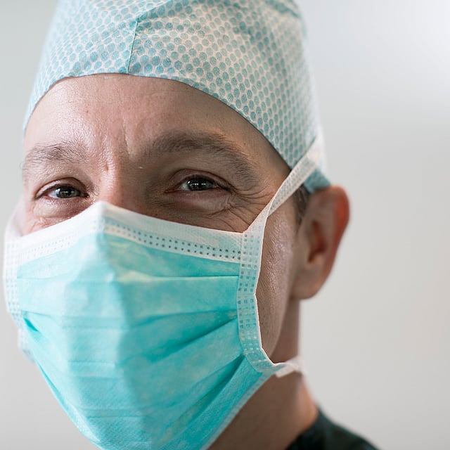 Une personne portant un masque chirurgical et une casquette.