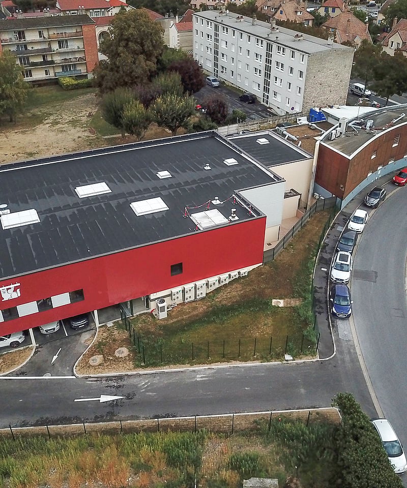 Un bâtiment avec des voitures garées sur le côté.