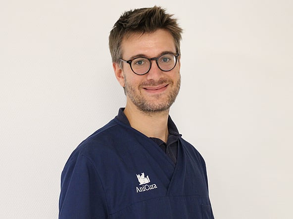 Une personne portant des lunettes et un chandail bleu.