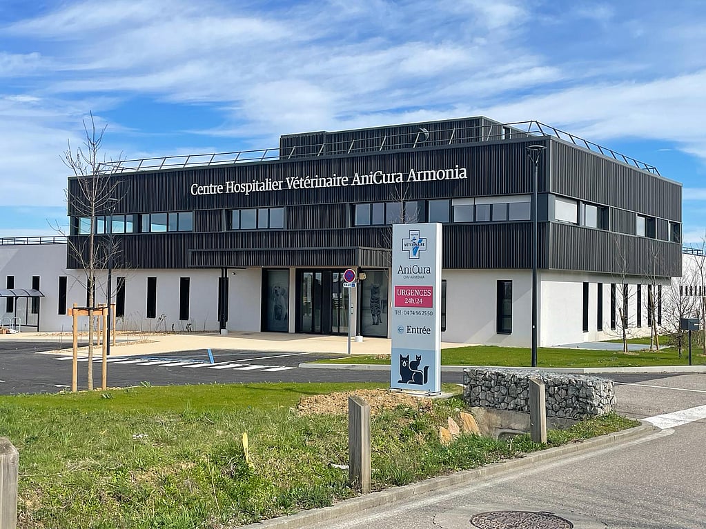 Un bâtiment avec un panneau devant lui.
