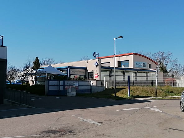 Un bâtiment avec une clôture et un portail.
