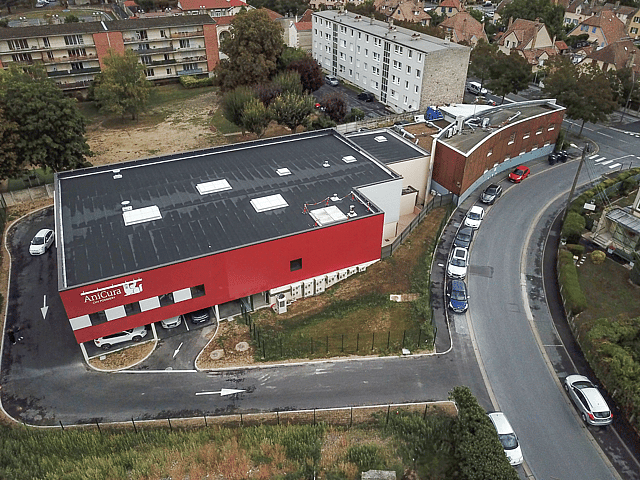 Un bâtiment avec des voitures garées sur le côté.